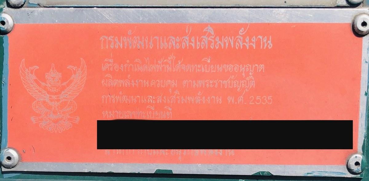 ป้ายทะเบียนเครื่องกำเนิดไฟฟ้าสีส้ม ตราครุฑ ของกรมพัฒนาและส่งเสริมพลังงาน ระบุว่าจดทะเบียนขออนุญาตผลิตพลังงานควบคุมตามพระราชบัญญัติการพัฒนาและส่งเสริมพลังงาน พ.ศ. 2535